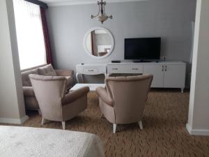 - un salon avec deux chaises et une télévision dans l'établissement Cihan Hotel, à Hopa
