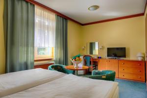 a hotel room with a bed and a table and chairs at Ensana Vila Trajan in Piešťany