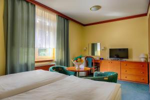 ein Hotelzimmer mit einem Bett, einem Tisch und Stühlen in der Unterkunft Ensana Vila Trajan in Piešťany