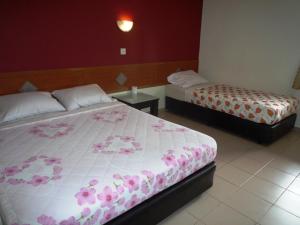 a bedroom with two beds with pink flowers on them at Lotus Hotel Johor Bahru in Johor Bahru