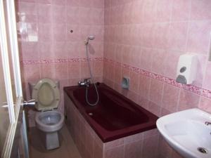 a bathroom with a tub and a toilet and a sink at Lotus Hotel Johor Bahru in Johor Bahru