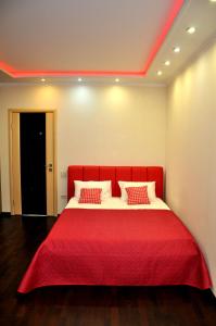 ロストフ・ナ・ドヌにあるApartment on Gvardeyskiyの赤いベッド1台(赤い毛布付)が備わるベッドルーム1室が備わります。