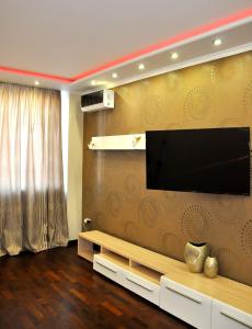 uma sala de estar com uma televisão de ecrã plano na parede em Apartment on Gvardeyskiy em Rostov on Don