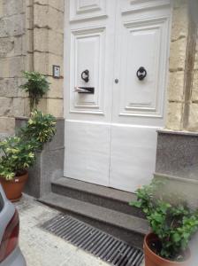 a white door on a building with two potted plants at Private room in Valletta