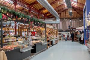 Un gran supermercado con gente caminando por los pasillos. en Maison avec terrasse Colmar Centre-Cottage garden terrace Center Old Town Colmar, en Colmar