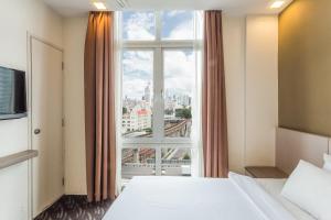 Schlafzimmer mit einem großen Fenster mit Stadtblick in der Unterkunft Scott Hotel KL Sentral in Kuala Lumpur