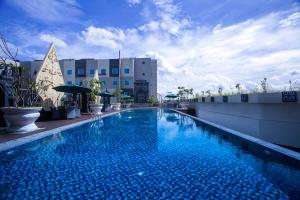 uma grande piscina ao lado de um edifício em ibis Yogyakarta Adi Sucipto em Yogyakarta