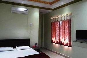 a bedroom with a bed and a red window at Hotel Parvati Palace Sehore in Sehore