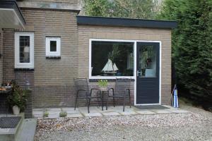 eine Terrasse mit einem Tisch und Stühlen in einem Gebäude in der Unterkunft Zeeland aan Zee in Burgh Haamstede