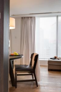 a room with a table and a chair and a window at The Jervois in Hong Kong