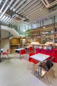 ein Esszimmer mit Tischen und roten Stühlen in der Unterkunft Scott Hotel KL Sentral in Kuala Lumpur