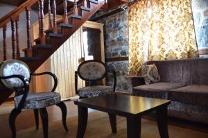 sala de estar con 2 sillas, sofá y mesa en Gioras Hotel, en Palaios Agios Athanasios