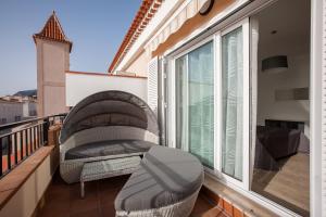 a balcony with a chair and a window at Residencial Playa de La Arena in Puerto de Santiago