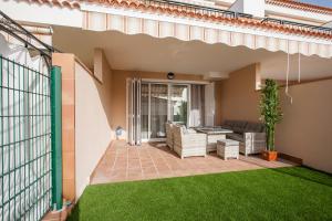 a patio with a lawn in front of a house at Residencial Playa de La Arena in Puerto de Santiago