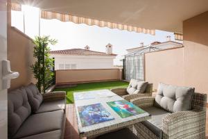 a patio with two couches and a table on a balcony at Residencial Playa de La Arena in Puerto de Santiago