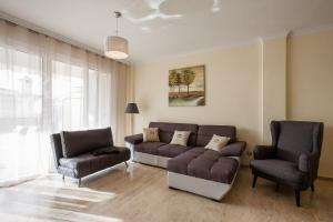 a living room with a couch and two chairs at Residencial Playa de La Arena in Puerto de Santiago