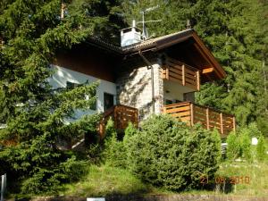 a house in the woods with a balcony at Chalet Villa Bianca in Tesero