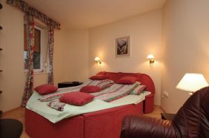 ジュラにあるCsillag Deluxe Apartmanの赤いベッド1台(赤い枕付)が備わるベッドルーム1室を提供しています。
