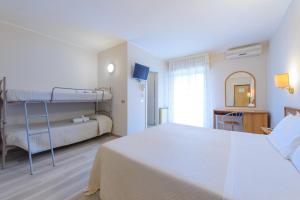 um quarto com uma cama e um beliche em Hotel Falco em Riccione