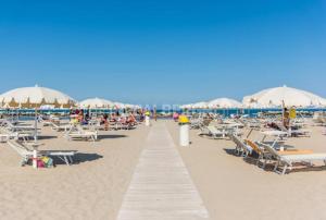 a beach with chairs and umbrellas and people on it at Hotel Rosy in Rimini