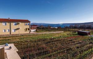 a farm with a fence and a house in the background at Apartments ZZ in Posedarje