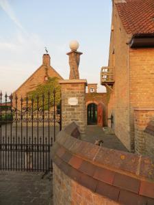 a dog sitting in front of a iron fence at B&B 't Hannonshof in Nieuwpoort