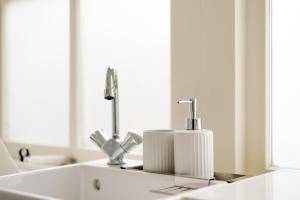 a bathroom sink with two faucets and a mirror at Rembrandt Studio's in Amsterdam