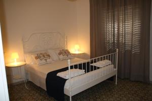シラクーサにあるShort Lets Villa al Mare Siracusaのベッドルーム(白いベッド1台、ランプ2つ付)