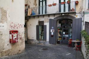 un vicolo con un edificio con dei graffiti di Le Mulieres a Salerno