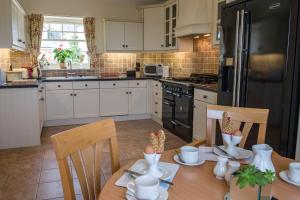 a kitchen with a table and chairs and a refrigerator at Loaninghead Holidays in Drymen