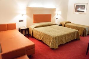 une chambre d'hôtel avec deux lits et un canapé dans l'établissement Hotel Fontanelle, à Fratta Terme