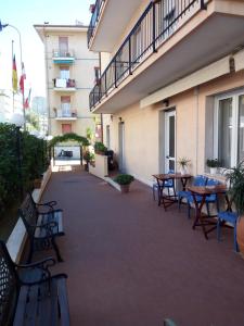 a balcony with tables and chairs in a building at Hotel San Nazario in Varazze