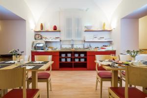 uma cozinha com armários vermelhos, mesas e cadeiras em Hotel Garibaldi em Palermo