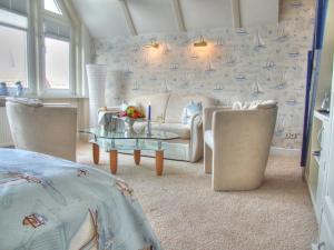 a living room with a couch and chairs and a table at Vogel Hotel & Appartements in Warnemünde