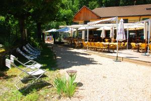 a group of chairs and tables and umbrellas in front of a building at Auberge de Portout in Chanaz