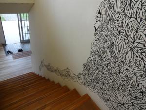 a hallway with a black and white mural on the wall at Minshuku Namisou in Iriomote