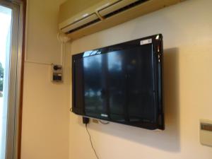 a flat screen tv hanging on a wall at Minshuku Namisou in Iriomote