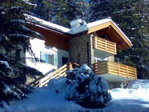 a house covered in snow in front of it at Chalet Villa Bianca in Tesero