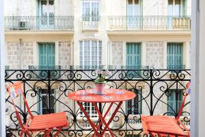 a table and two chairs on a balcony with a building at La Romantica Dante Five stars Holiday House in Nice