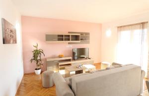 a living room with a couch and a tv at Apartments Andelic in Vinišće