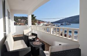 a balcony with chairs and a table and a view of the water at Apartments Andelic in Vinišće