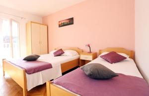 um quarto com 2 camas e uma janela em Apartments Andelic em Vinišće