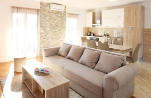 a living room with a couch and a table and a kitchen at Apartments Andelic in Vinišće