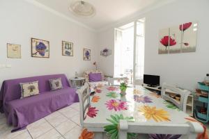 sala de estar con mesa y sofá púrpura en La Romantica Dante Five stars Holiday House, en Niza