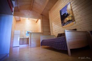 a wooden room with a bed and a refrigerator at Résidence Marina Livia in Serriera