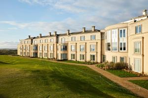 a large building with a grass field in front of it at Portmarnock Resort & Jameson Golf Links in Portmarnock