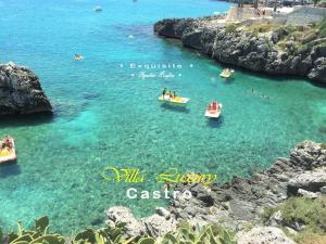 un grupo de barcos en un cuerpo de agua con rocas en Villa Luxury, en Castro di Lecce