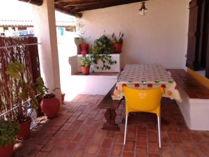 einen Tisch und zwei Stühle auf einer Terrasse in der Unterkunft Casa das Hortências By Alojamentos Vitinho - Vila Nova MIlfontes in Vila Nova de Milfontes