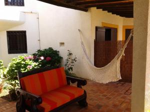 eine Veranda mit einer Hängematte und einem Stuhl in der Unterkunft Casa das Hortências By Alojamentos Vitinho - Vila Nova MIlfontes in Vila Nova de Milfontes