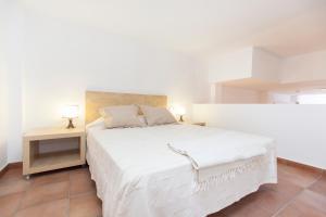 1 dormitorio con 1 cama blanca grande y 2 mesas en Stay Barcelona Vila de Gracia, en Barcelona